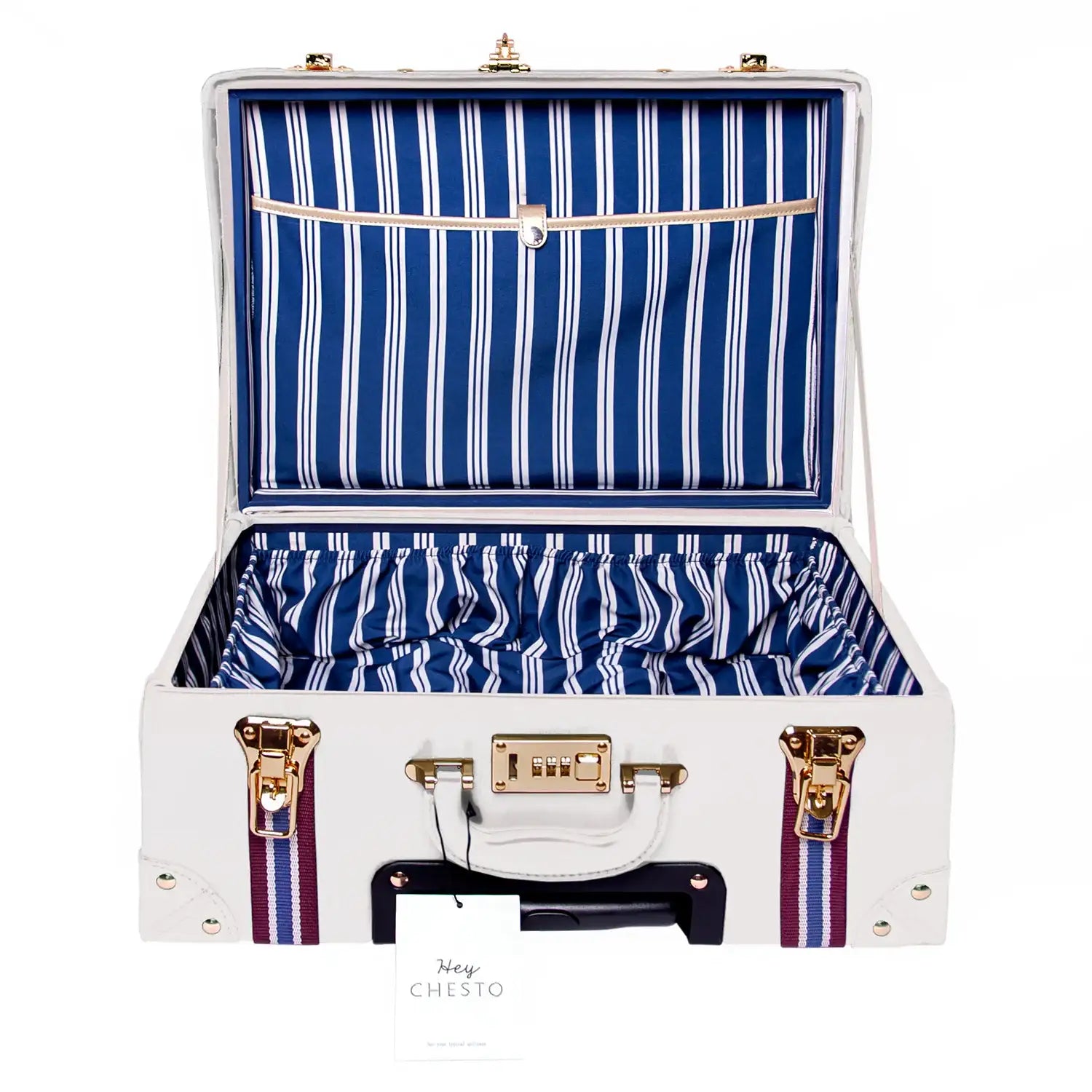 White vegan leather suitcase with navy stripe lining, gold hardware, and striped straps — minimalist luxury travel case