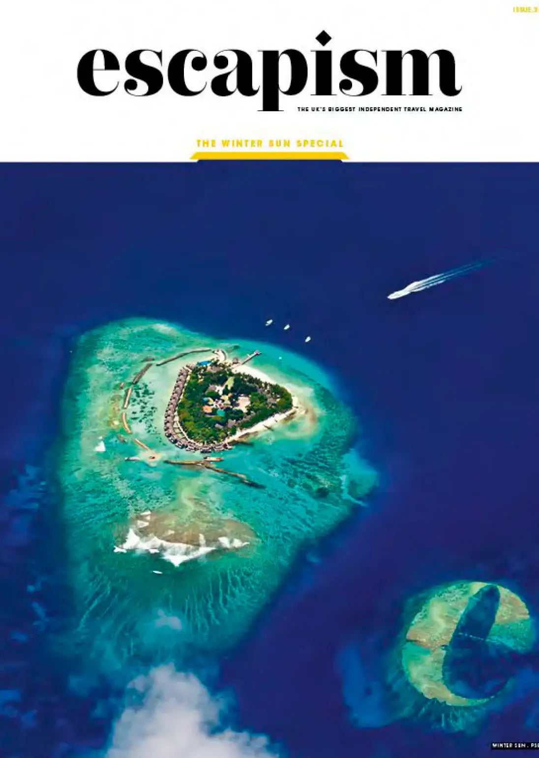 Escapism magazine cover featuring tropical island resort, turquoise waters, and speedboat — Winter Sun Special issue